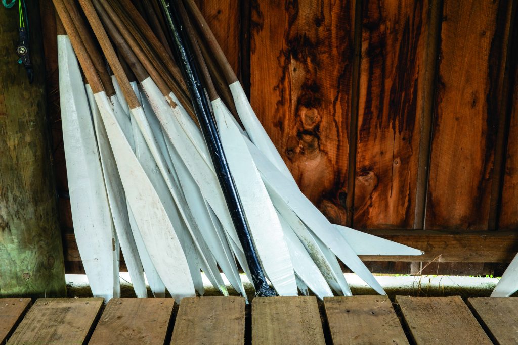 Some of the waka paddles and one of the museum’s old waka in its shed, showing its fine bow carving. Waka paddles at Okains Bay Marae (Up the creek: Old boats heaven) // Photo credit: Lesley Stone