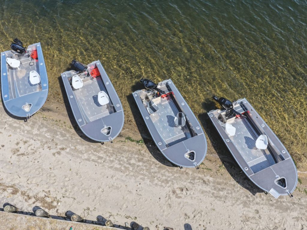 All four boats lined up on the shore.