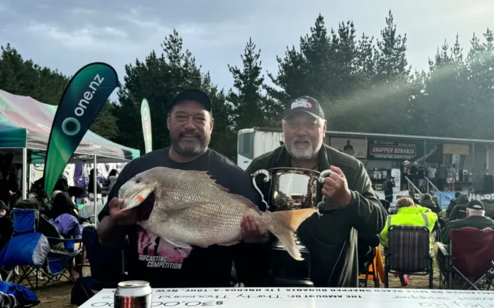 Harley Ra with his winning fish, the trophy and his father John Ra, known in Kaitāia for his expertise in making fishing rigs. Photo- Supplied