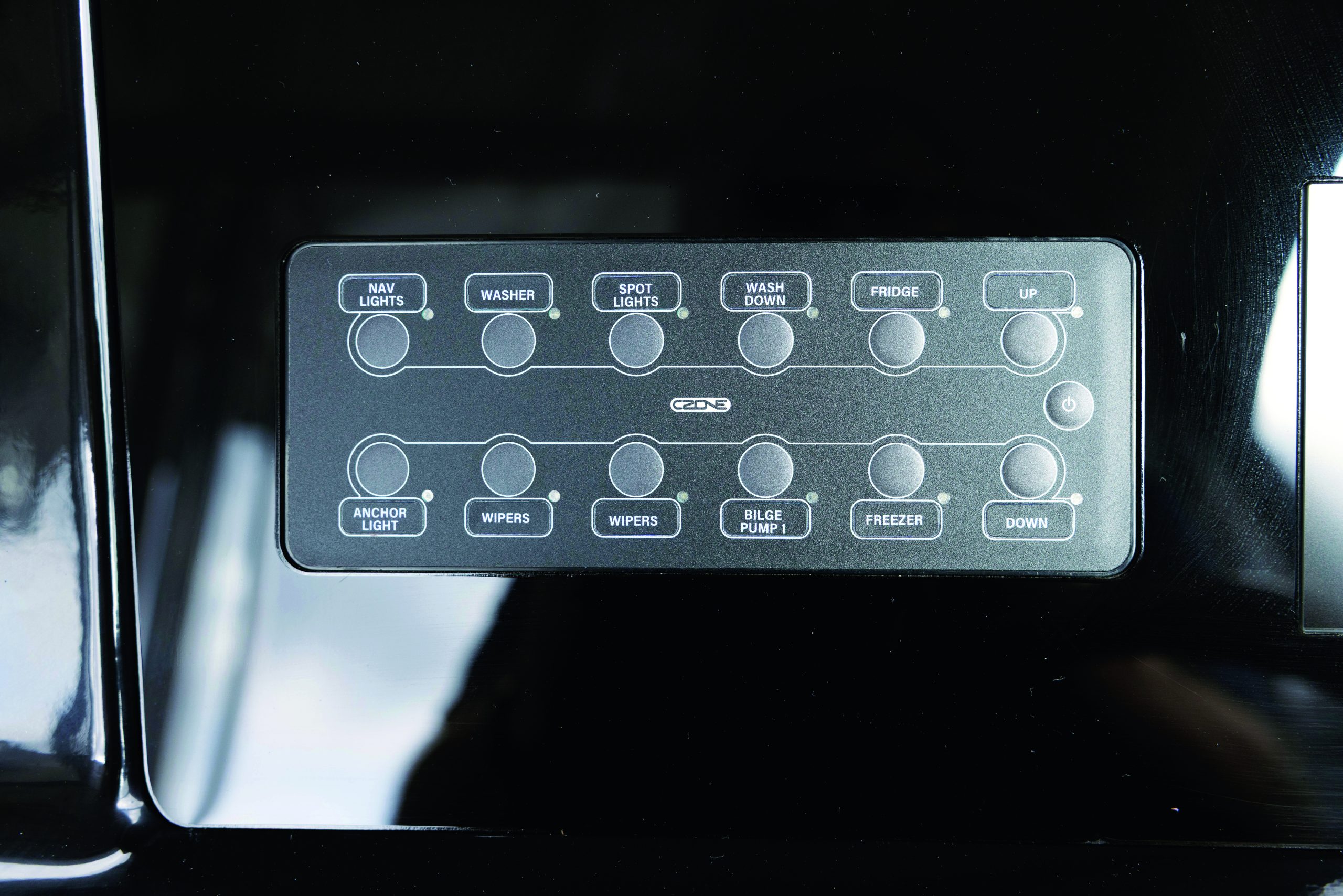 A boat's electrical control panel displays switches for navigation lights, washer, spotlights, wash down, fridge, anchor light, wipers, bilge pump, and freezer functions // Photo credit: supplied.