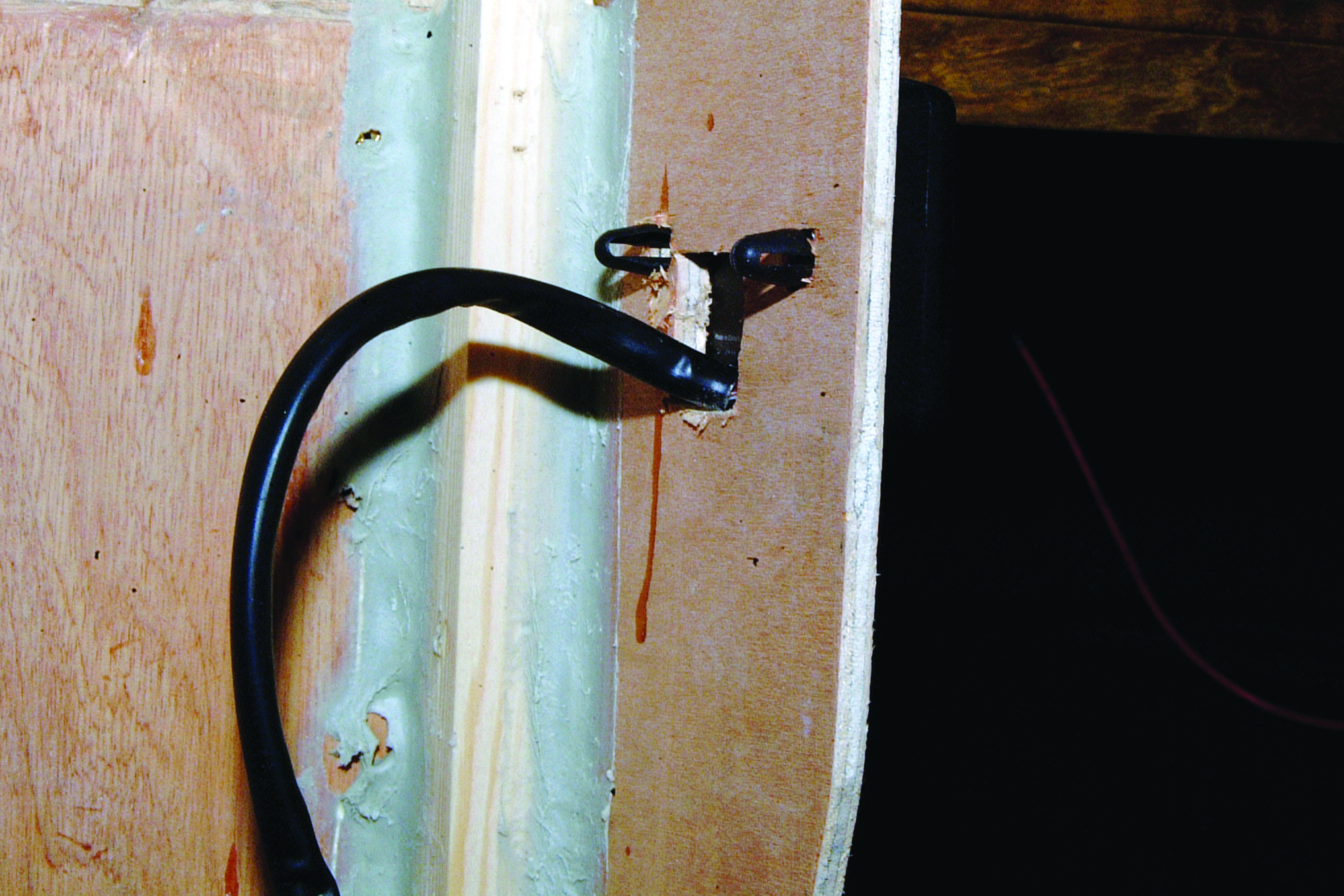 A black curved pipe or hose extends from a boat's hull near the waterline, with rust stains visible on the white painted surface // Photo credit: supplied.