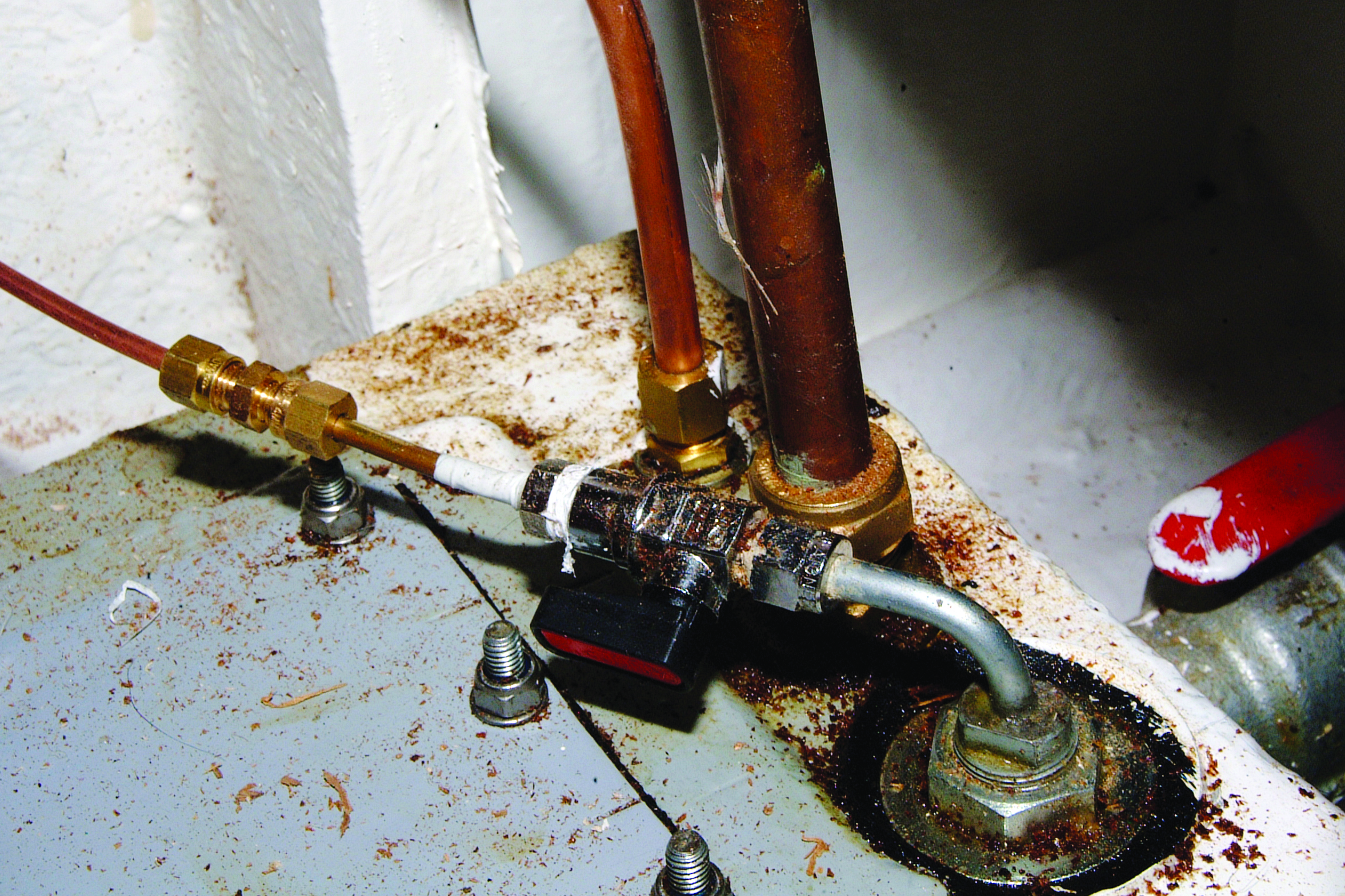 A water meter with copper pipes shows signs of corrosion and rust in what appears to be a boat's engine compartment or utility area // Photo credit: supplied.