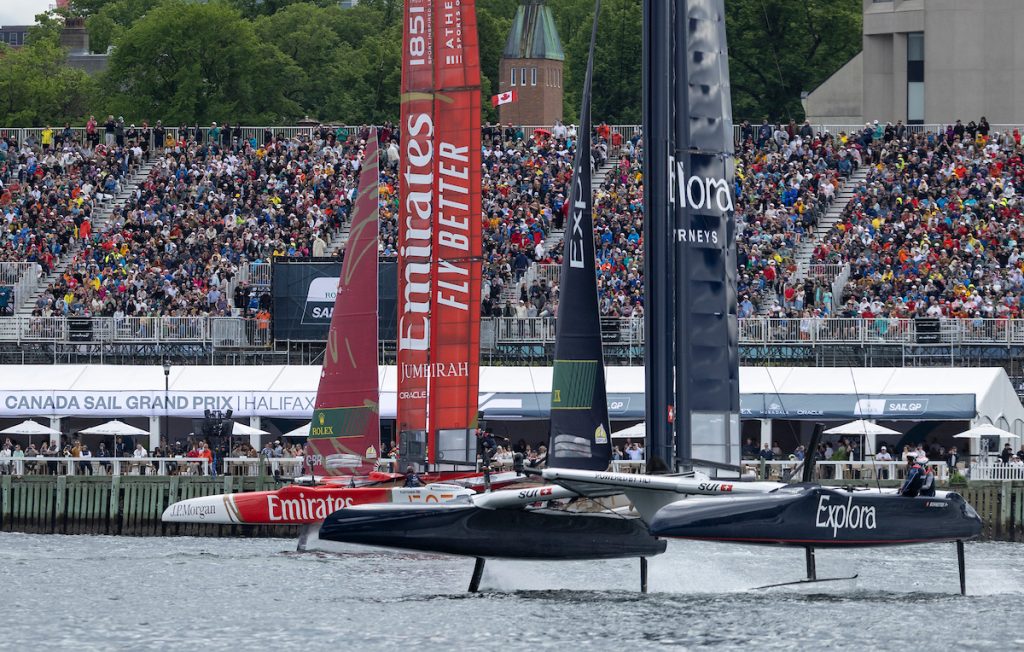 Emirates Great Britain SailGP Team driven by Dylan Fletcher leads Explora Journeys Swiss SailGP Team driven by Sebastien Schneiter past the SailGP Race Stadium and Grandstand on Race Day 1 of the Canada Sail Grand Prix in Halifax, Canada. Saturday 20 June 2026. Rolex SailGP Championship Event 7 2026 Season. // Photo credit: Samo Vidic for SailGP.