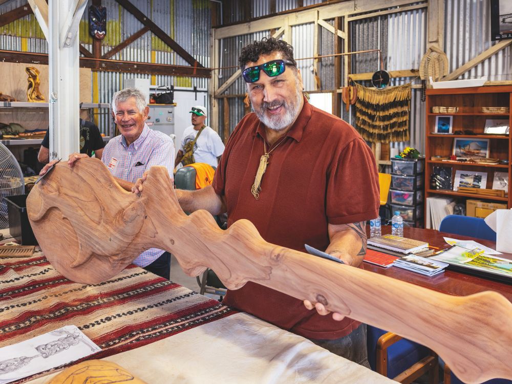Master carvers at work on a waka hourua at the 2026 Auckland Wooden Boat Festival. // Photo credit: Roger Mills
