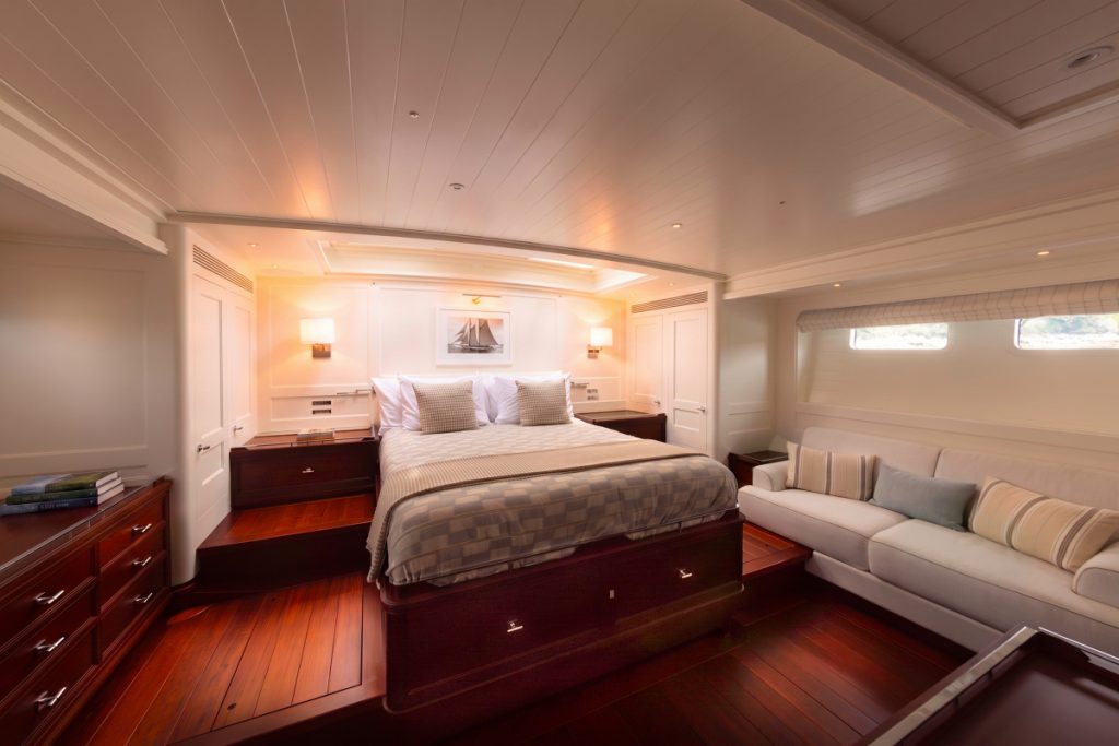 The owner’s stateroom aboard Ouzel features a centerline berth, built-in settee, and extensive mahogany cabinetry. // Photo credit: Russell Kaye