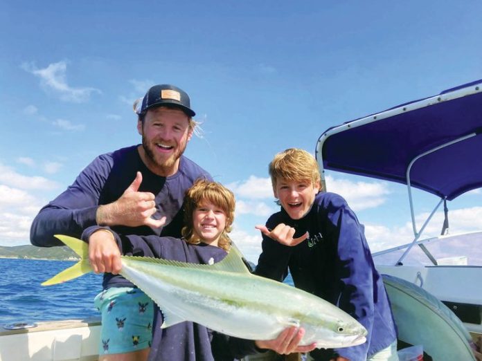 Captain Quinn with his two boys and a Kiwi kingfish.