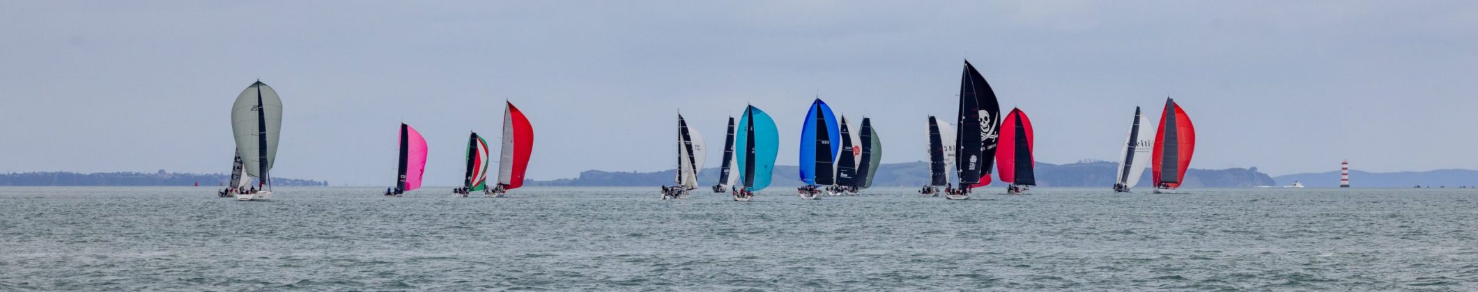 The fleet fan out across Waitemata Harbour as they edge their way up towards the top mark in the Gulf in the 2026 Roy McDell Memorial Cup.