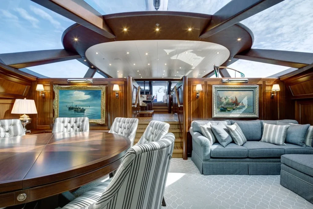 Overhead glazing brightens the lower saloon, where formal dining shares space with comfortable seating and maritime paintings - Encore superyacht // Photo courtesy McD Yachts