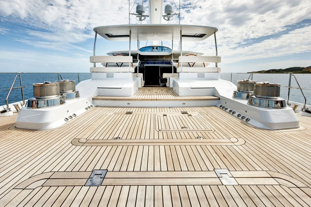The expansive teak aft deck leads forward past substantial winches towards the sheltered cockpit - Encore superyacht // Photo courtesy McD Yachts
