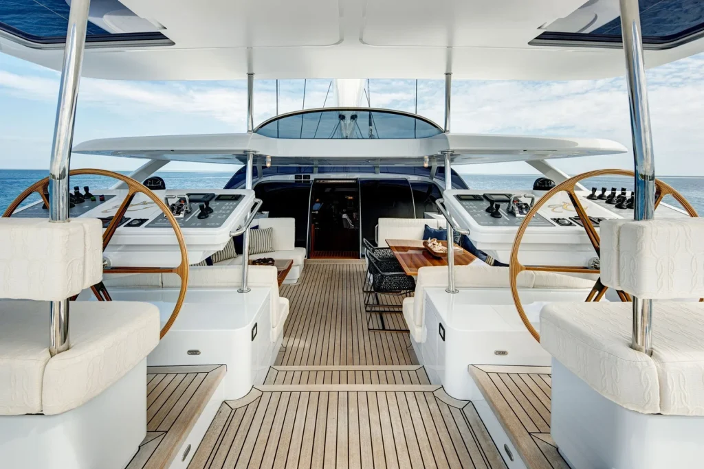 Twin wheels flank the sheltered cockpit, where generous seating and dining tables invite long lunches at anchor - Encore superyacht // Photo courtesy McD Yachts