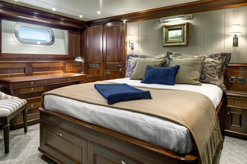 Warm timber joinery, a leather finished desk and a queen berth give this guest cabin a comfortable, traditional feel - Encore superyacht // Photo courtesy McD Yachts