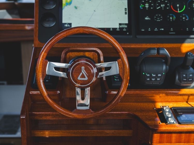 A timber steering wheel sits alongside digital displays, throttle controls and a joystick at the P50’s helm. // Photo courtesy Spirit Yachts